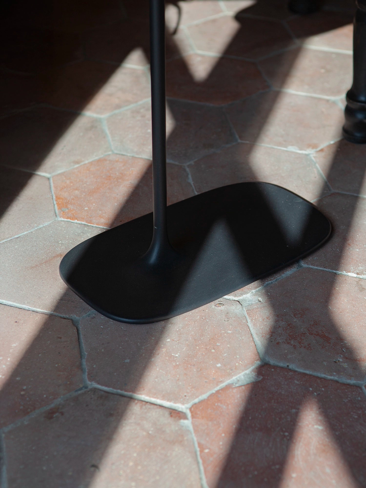Matte black sand-cast texture on a low Fluid side table, highlighting the raw industrial finish.